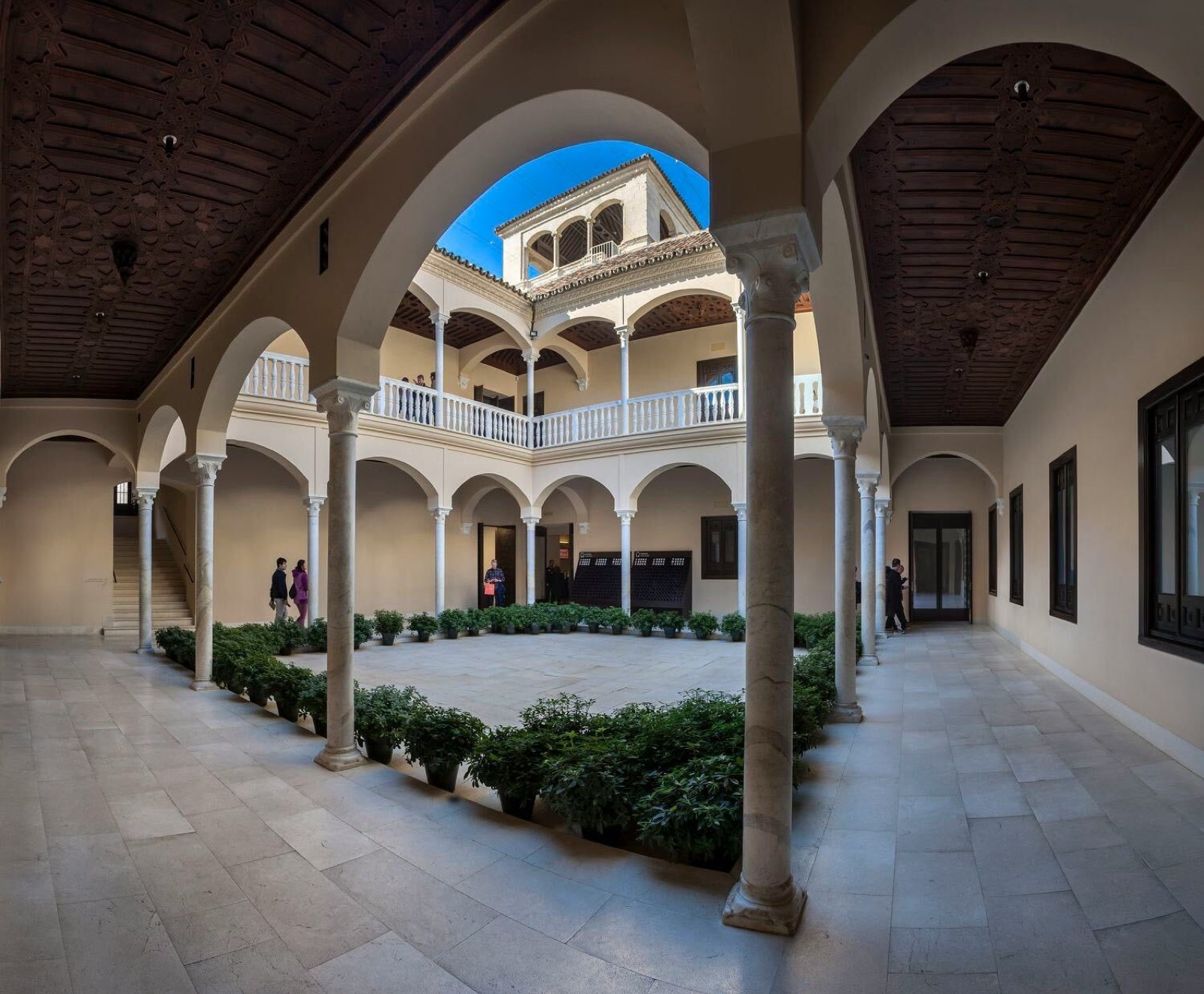 The courtyard galleries under the carved wooden ceiling